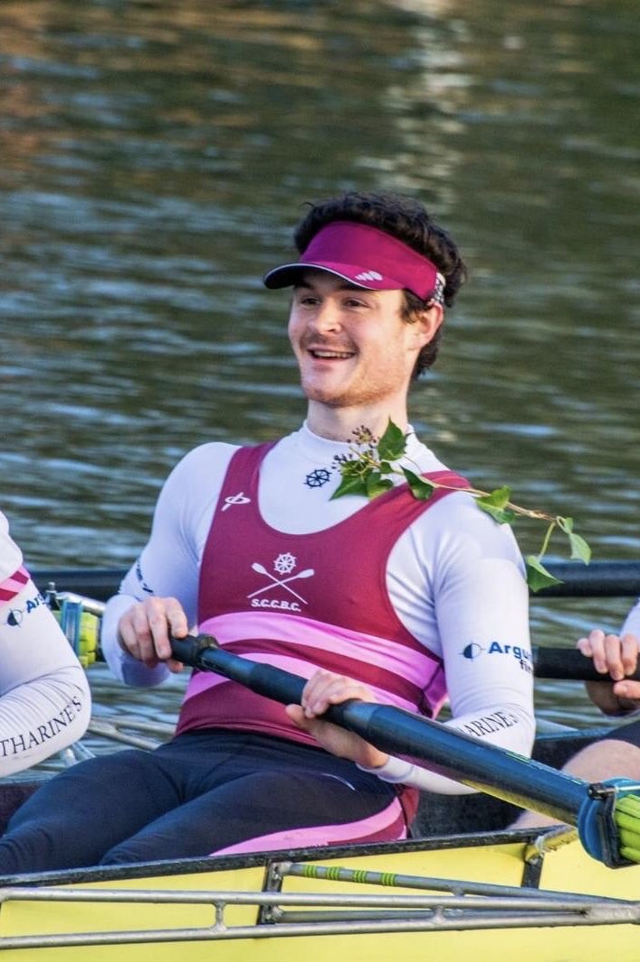 Rowing an 8+ with a very cheesy grin.